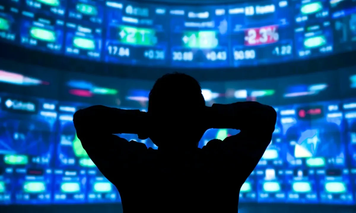 young man standing in front of the projection reflected stock market