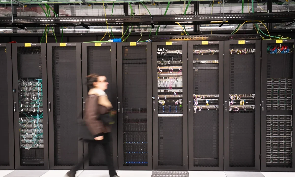 A visitor walks past a computer bay at the PA10 data center, operated by Equinix Inc., in Paris, France.