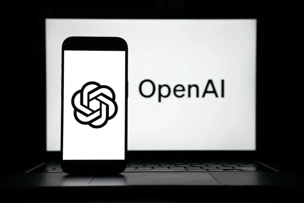 the logos of Open AI displayed on both computer and smart phone screen