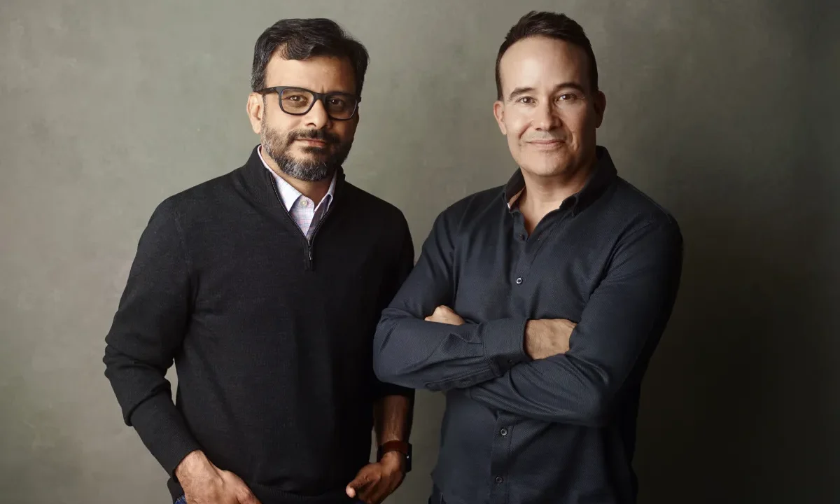 a picture showing the co-founders of Kana, Tom Chavez and Vivek Vaidya, leaning against a grey background