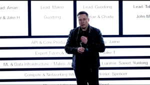 Elon Musk stands in front of xAI's new org chart