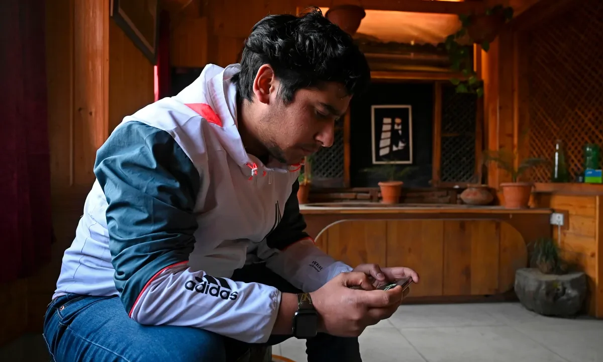 seated man looking at ell phone