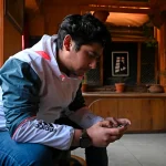 seated man looking at ell phone