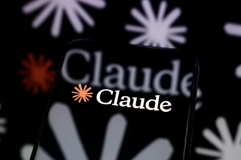 The Claude logo is displayed on a smartphone screen placed on a reflective surface onto which a multitude of Claude logos are projected.