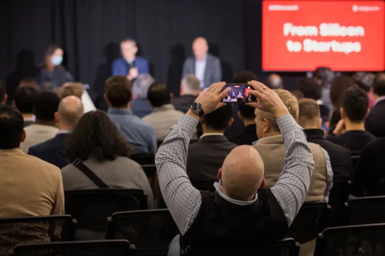 An attendee at a StrictlyVC 2025 event taking a photograph