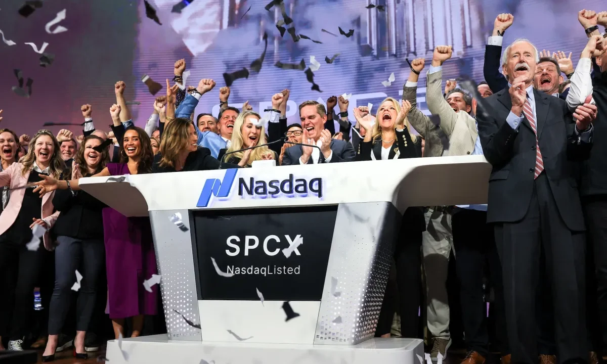 Bret Johnsen (C), SpaceX Chief Financial Officer, and Gwynne Shotwell (center R), SpaceX President and Chief Operating Officer, celebrate as they ring the opening bell at the Nasdaq MarketSite to celebrate the launch of SpaceX’s initial public offering (IPO) in New York on June 12, 2026.