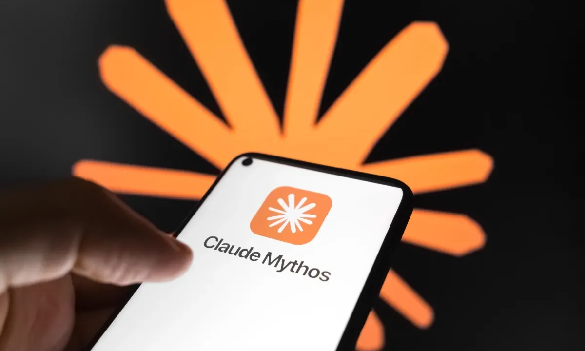 The Claude Mythos logo appears on a smartphone screen, and the Claude AI logo displays as the background on a laptop computer screen.