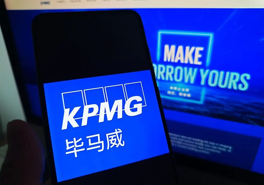 SUQIAN, CHINA - MAY 19, 2026 - A netizen is checking KPMG logo on his mobile phone and KPMG webpage on his computer in Suqian City, Jiangsu Province, China on May 19, 2026. (Photo credit should read CFOTO/Future Publishing via Getty Images)