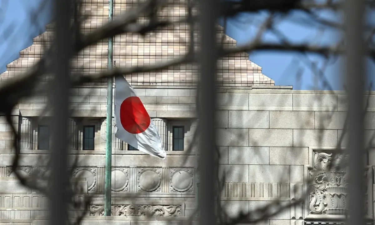 a Japanese flag fluttering in the wind in the distance in front of a building in Tokyo