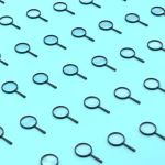 Repeated Magnifying Glass On Blue Background