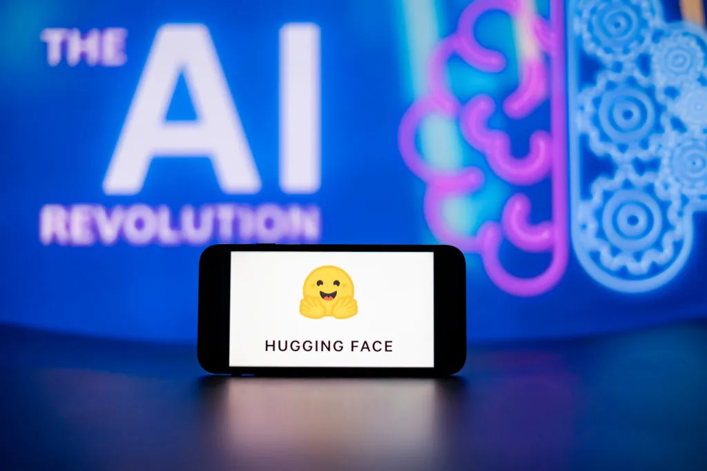 In this photo illustration, the Hugging Face logo seen displayed on a mobile phone screen with the AI (artificial intelligence) revolution symbol in the background.