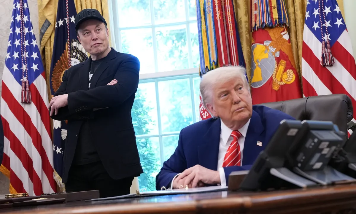 Tesla CEO Elon Musk and U.S. President Donald Trump listen to a question from reporters in the Oval Office of the White House.
