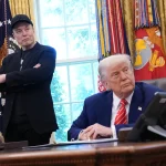 Tesla CEO Elon Musk and U.S. President Donald Trump listen to a question from reporters in the Oval Office of the White House.