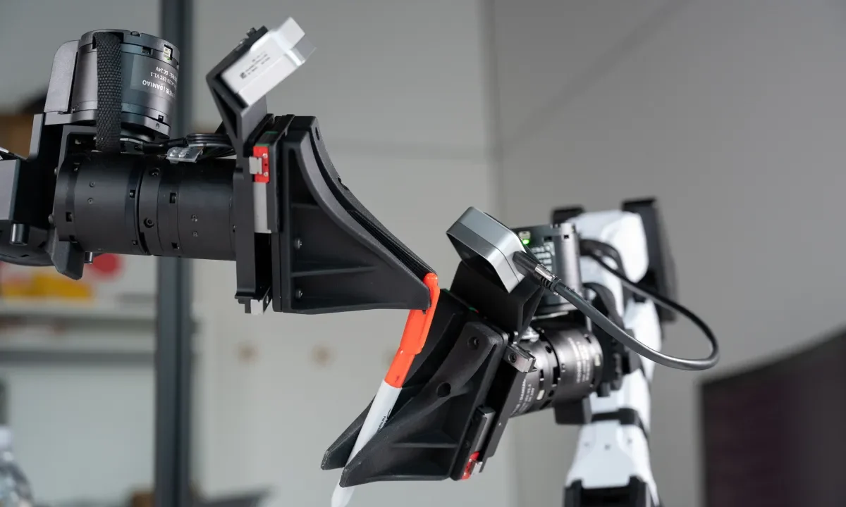 XDOF's robotic arms manipulate a pen and cap.