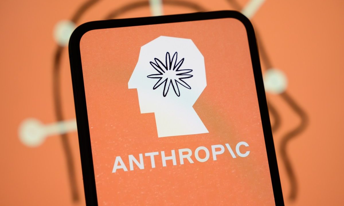 The Anthropic logo is displayed on the screen of a smartphone with the company's branding in the background.