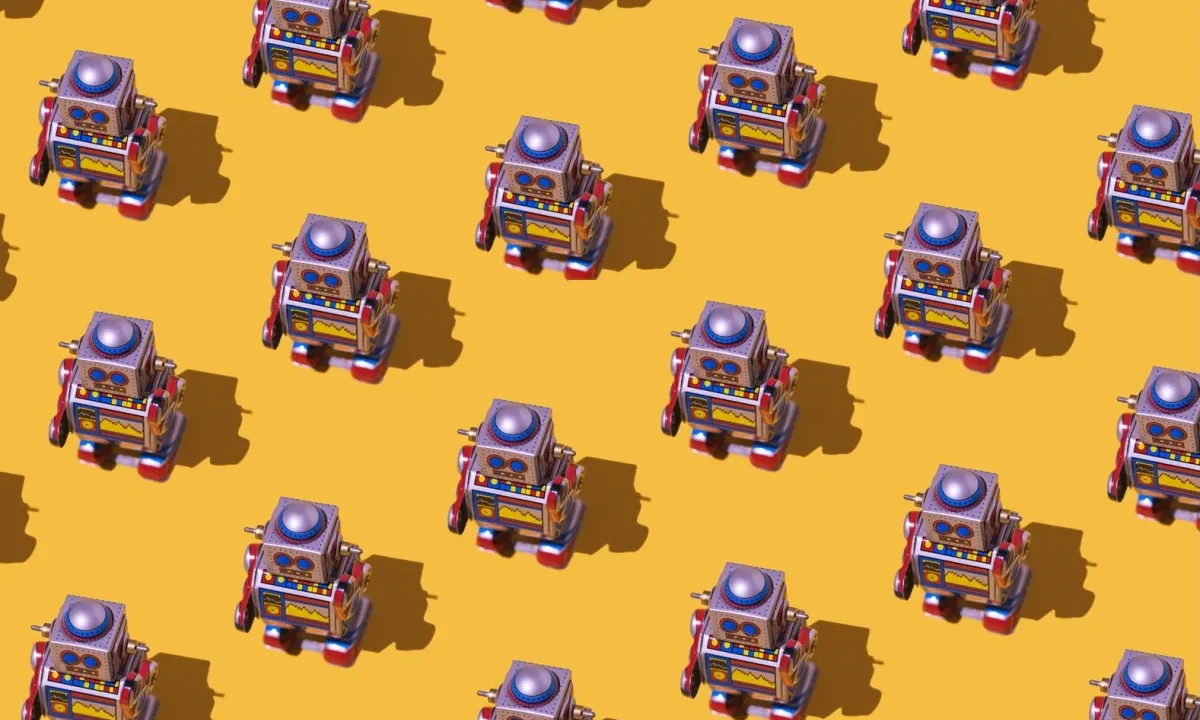 Pattern of retro tin toy robots with clocks and displays painted on yellow background.